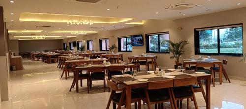 a restaurant with wooden tables and chairs and windows at Fortune Statue Of Unity, Ekta Nagar - Member ITC Hotels' Group in Kevadia