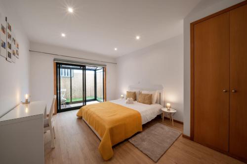 a bedroom with a bed and a large window at Beira Mar Sunny Patio in Aveiro
