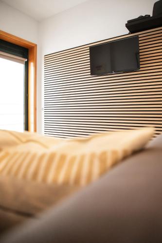a bedroom with a bed with a tv on a wall at Beira Mar Sunny Patio in Aveiro