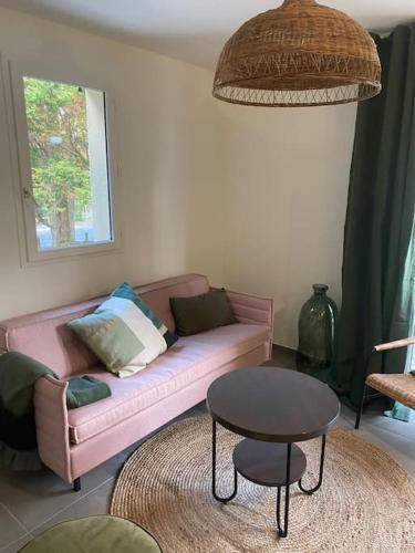 un salon avec un canapé rose et une table dans l'établissement Nouveau ! Cottage dans une résidence arborée Pinwood, à Neufchâtel-Hardelot