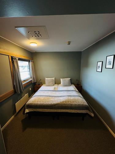 ein Schlafzimmer mit einem großen Bett in einem Zimmer in der Unterkunft Helgatun Fjellpensjonat AS in Vossestrand