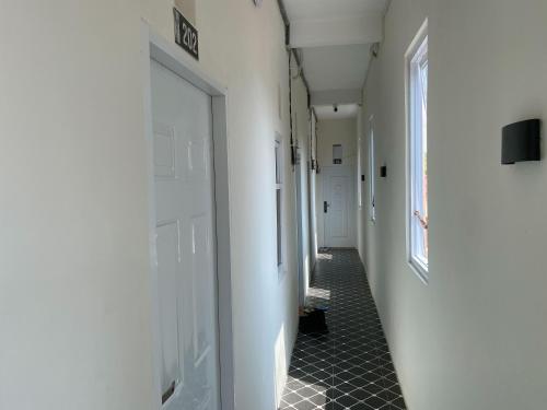 a hallway with white doors and a black tile floor at Duta Elite Kostel Syariah near RSUD Caruban Redpartner in Madiun