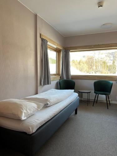 um quarto com uma cama, 2 cadeiras e uma janela em Helgatun Fjellpensjonat AS em Vossestrand