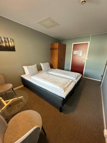 um quarto com uma cama num quarto com cadeiras em Helgatun Fjellpensjonat AS em Vossestrand
