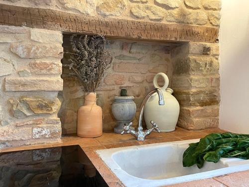 a stone wall with three vases and a sink at Castello di Granarola Relais - Adults Friendly - in Gradara