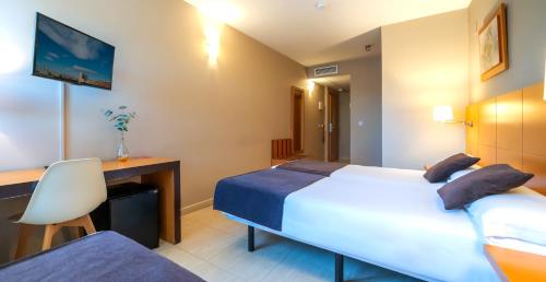 a hotel room with a bed and a desk at La City Estación in Alicante