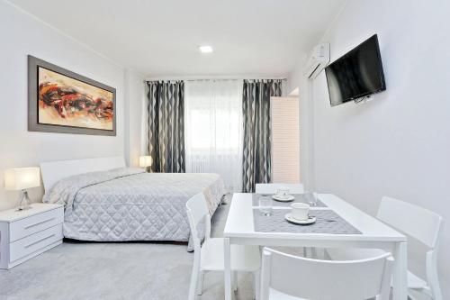 een witte slaapkamer met een bed en een tafel met stoelen bij Valery's Home in Rome