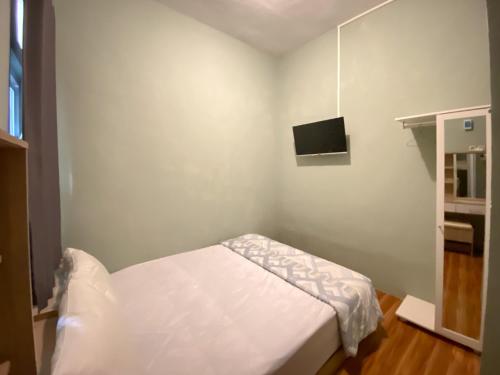 a small bedroom with a bed and a tv at Duta Elite Kostel Syariah near RSUD Caruban Redpartner in Madiun
