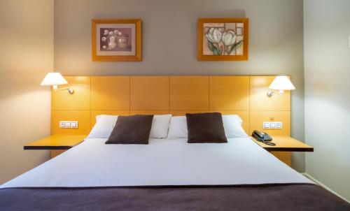a bedroom with a large white bed with two pillows at La City Estación in Alicante