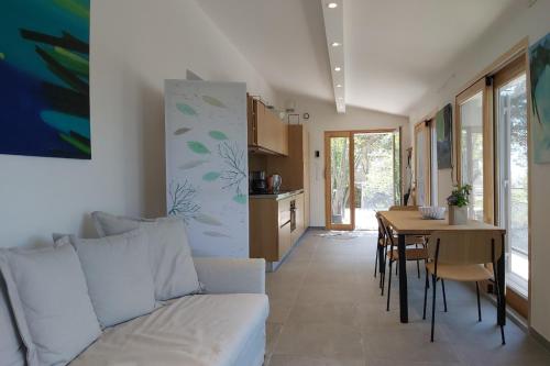 un soggiorno con un divano bianco e un tavolo di Sète - Maison entière et jardin sur le Mont Saint Clair - vue mer et étang a Sète