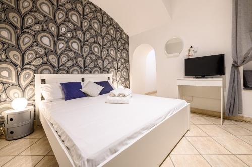 ein Schlafzimmer mit einem großen weißen Bett mit einer Wand in der Unterkunft Via Nilo 30 in Neapel