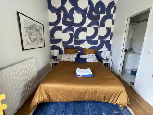 Un dormitorio con una cama con una pared azul y blanca en Chambre d'hôte Bords de Garonne, en Burdeos