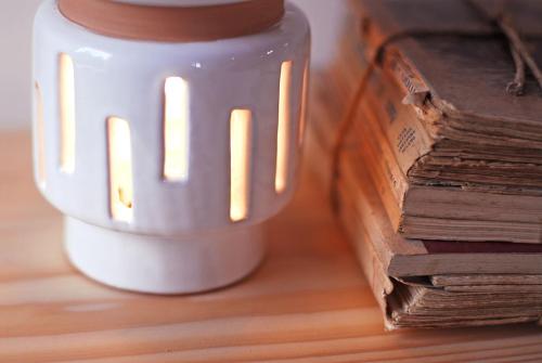 a white coffee mug next to a stack of books at Castello di Granarola Relais - Adults Friendly - in Gradara