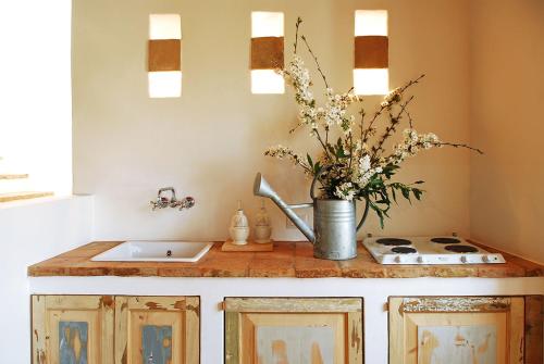 a kitchen counter with a sink and a vase of flowers at Castello di Granarola Relais - Adults Friendly - in Gradara