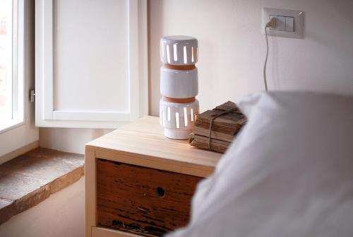 a nightstand with a lamp on top of a bed at Castello di Granarola Relais - Adults Friendly - in Gradara