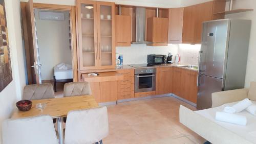 a kitchen with wooden cabinets and a table with chairs at Malvazios Villas #7 in Gythio