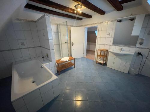 a large bathroom with a tub and a sink at Hotel - Ristorante La Grotta in Speyer