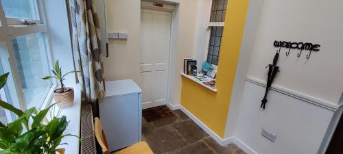 a small room with a white counter and a yellow wall at Private annex to Victorian villa, with kitchen and Free parking in Todmorden