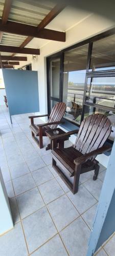 two chairs sitting on a porch with a blank screen at Greystone Guesthouse in Jeffreys Bay