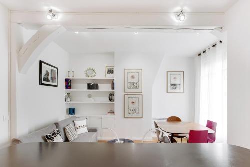 un salon blanc avec une table et des chaises dans l'établissement Pick A Flat's Apartment in Saint Germain - Rue de Buci, à Paris