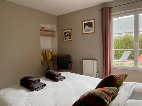 une chambre avec un lit avec deux serviettes dessus dans l'établissement La maison des Declos avec parking privé, à Bayeux
