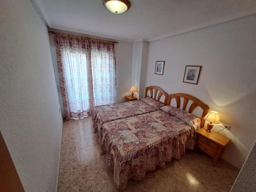 a bedroom with a bed with a table and two lamps at Apartamento Isla Grosa La Manga V.v. in La Manga del Mar Menor