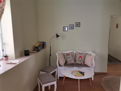 a living room with a white couch and a table at Аврамов дом - етаж от къща in Veliko Tŭrnovo