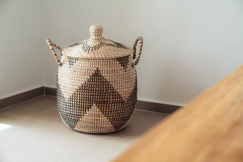 a wicker container sitting on the floor next to a wall at Melianthos Villas in Vathi, Sifnos