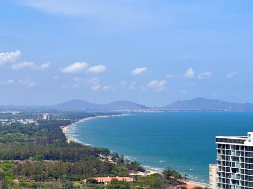 Blick auf das Meer und ein hohes Gebäude in der Unterkunft Song's Apartment - Căn Hộ Du Lịch Biển Vũng Tàu in Vũng Tàu