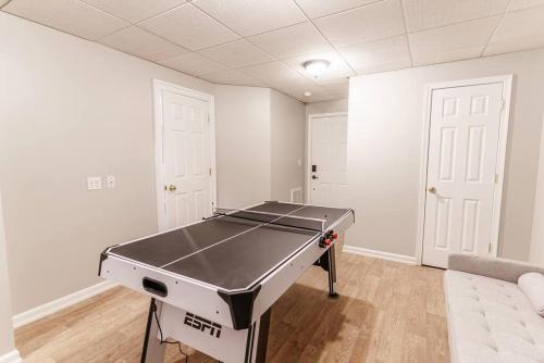 a ping pong table in a room with white walls at Mountain Views, Hot Tub, Firepit, dog friendly, EV connector in Stanley
