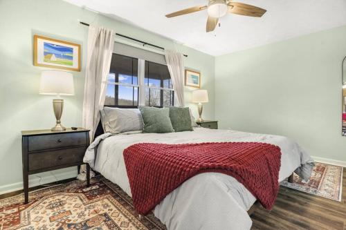 a bedroom with a bed with a red blanket and a window at Mountain Views, Hot Tub, Firepit, dog friendly, EV connector in Stanley
