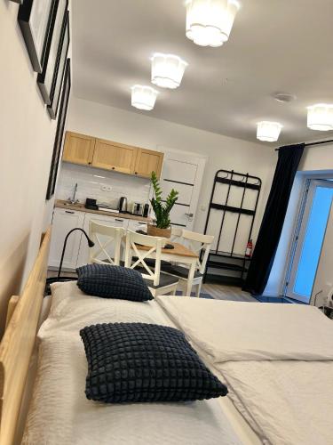 two beds in a room with a kitchen and a table at Apartmány Benešov in Benešov nad Ploučnicí