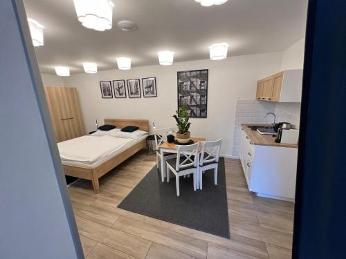 a room with a bed and a table and a kitchen at Apartmány Benešov in Benešov nad Ploučnicí