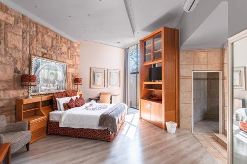 um quarto com uma cama king-size e uma casa de banho em Villa Africa Boutique Hotel & Spa em Pretoria