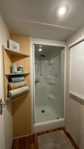une salle de bain avec une douche avec une porte vitrée dans l'établissement Ma Baie home, à Noyelles-sur-Mer