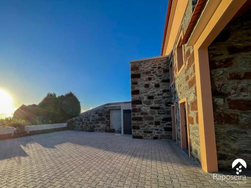 ein Gebäude mit einer Backsteinmauer und einer Garage in der Unterkunft Raposeira Country House in Calheta
