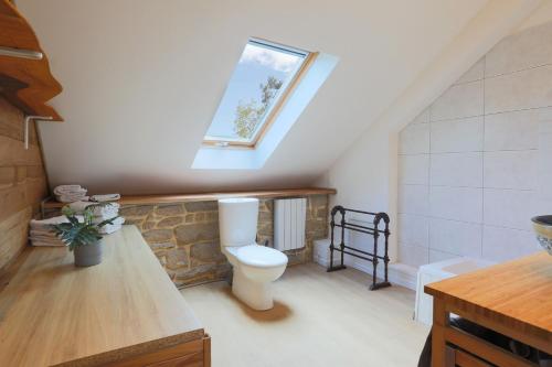 La salle de bains est pourvue de toilettes et d'une fenêtre. dans l'établissement Gite Relax a la Campagne, à Guern