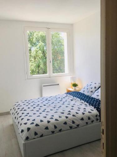 Ce lit se trouve dans un dortoir blanc doté de 2 fenêtres. dans l'établissement Superbe T4 ensoleillé avec balcon à Avignon, à Avignon