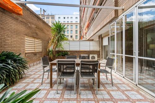 an outdoor patio with a table and chairs at Sunlit Expansive Terrace, Ac & Outdoor Seating in Barcelona