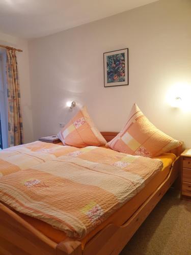 - un lit avec des oreillers dans une chambre dans l'établissement Ferienwohnung Hinterpommern - Chiemgaukarte, à Inzell
