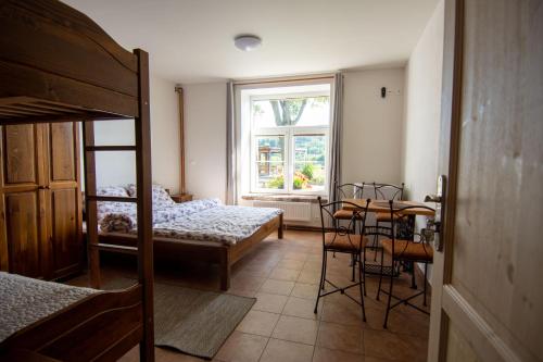 プルシーブラムにあるHornický penzionのベッド、テーブル、窓が備わる客室です。