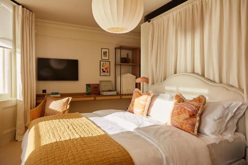 um quarto com uma grande cama branca com almofadas em No.124 by GuestHouse, Brighton em Brighton & Hove
