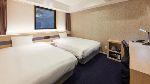 um quarto de hotel com duas camas e uma televisão em Henn na Hotel Kagoshima Tenmonkan em Kagoshima