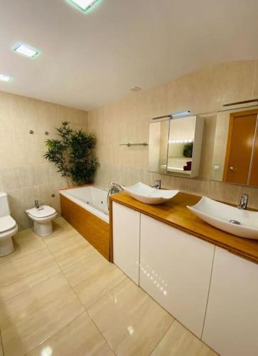 a bathroom with two sinks and a tub and a toilet at Moderno Dúplex in Malgrat de Mar
