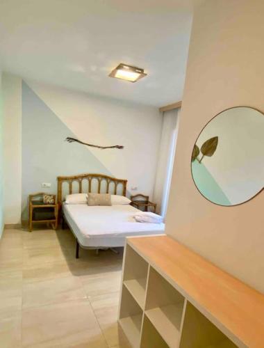 a bedroom with a bed and a mirror on the wall at Moderno Dúplex in Malgrat de Mar