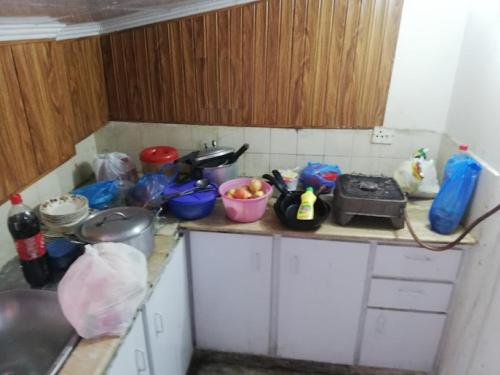 un mostrador de cocina con un montón de platos. en Jalwa Residential, en Murree