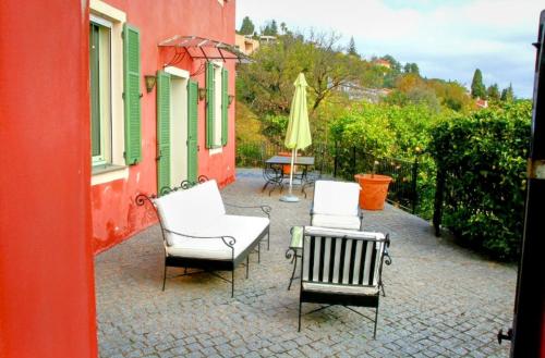 un patio avec deux chaises, une table et un parasol dans l'établissement La Bastide, à Vallauris