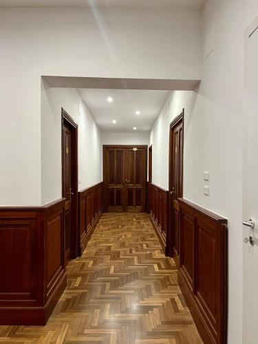 an empty hallway with wooden doors and wooden floors at Domus Giovanna in Rome