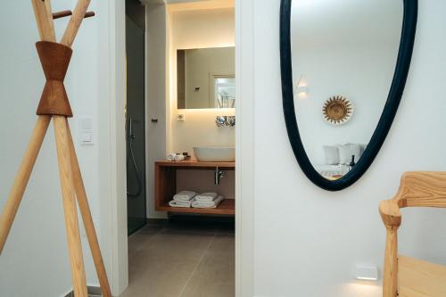 a bathroom with a mirror and a wooden tripod at Melianthos Villas in Vathi, Sifnos