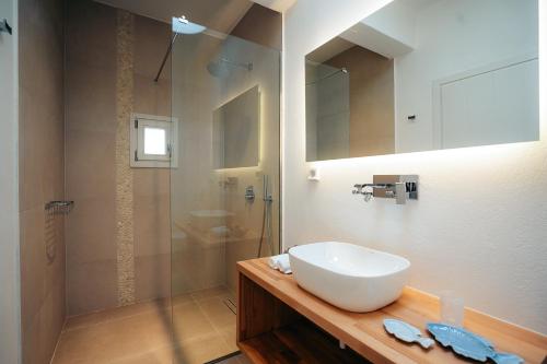 a bathroom with a white sink and a shower at Melianthos Villas in Vathi, Sifnos